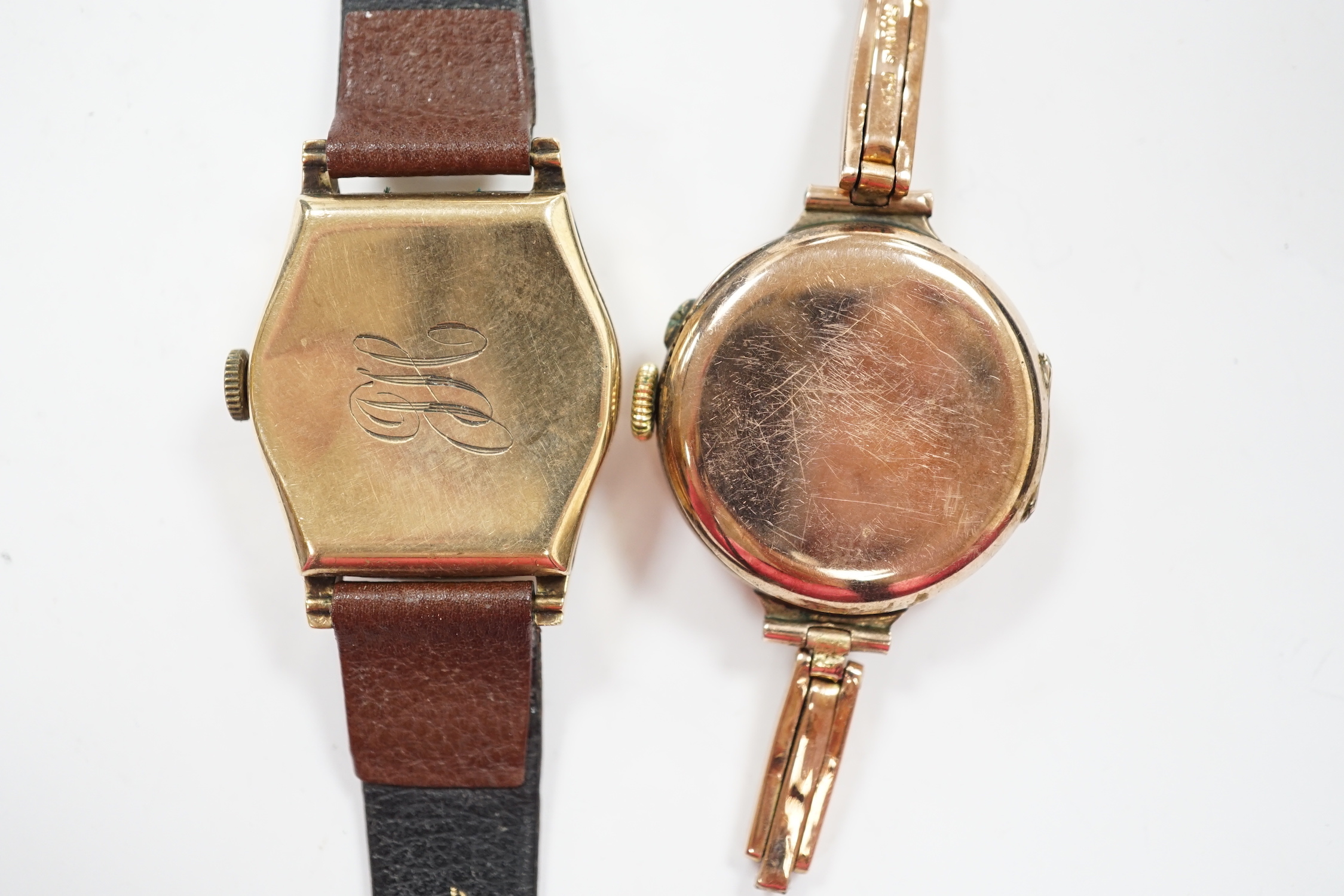 A lady's early 20th century 9k manual wind wrist watch, on an expanding 9ct bracelet(a.f.), together with a lady's 1930's 9ct Tavanne manual wind wrist watch, on a leather strap.